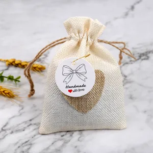 Burlap drawstring gift bag featuring a cute heart patch and a handmade bow hang tag for packaging.