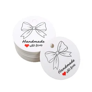 Round white paper gift tags with black bow and handmade with love print for baking packaging.