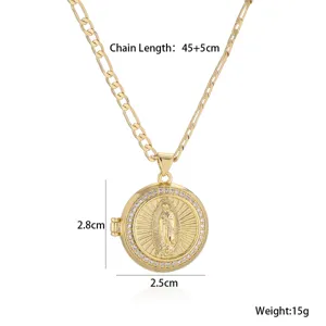Gold locket pendant necklace detail with religious engraving and sparkling rhinestones.