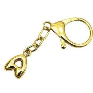 Gold-plated bubble letter keychain detail shot, featuring lobster clasp and shiny metal finish.