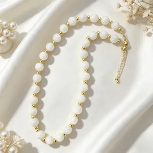 Elegant white beaded clavicle chain with gold spacer beads, minimalist chic design for women.
