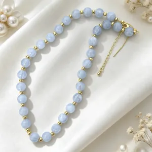 Elegant light blue acrylic beaded necklace with gold metal accents, perfect detail jewelry shot.