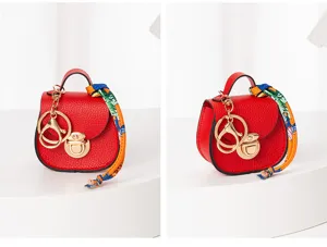 Detalle de mini llavero bolso de silla rojo, cuero PU con cierre dorado y pañuelo.