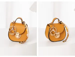 Mini bolso de silla llavero amarillo con cierre de anillo metálico y detalle de pañuelo.