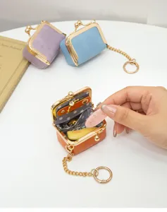 Close-up detail of mini PU leather kiss lock jewelry bag ring coin purse with chain.