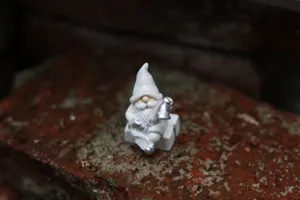 Figurine de père Noël blanche en résine avec cloche argentée pour déco de Noël.