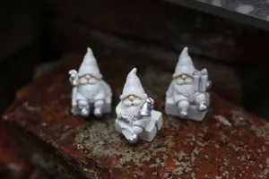 Ensemble de figurines de lutin du Père Noël en résine blanche, idéal pour la déco de table de fête.