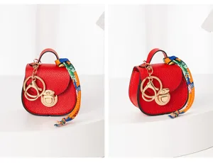Mini bolso de silla de montar llavero rojo con herrajes dorados y detalle de cinta.