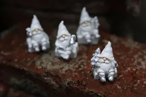 Détail en gros plan d'un ensemble de figurines de lutins de Noël en résine blanche.