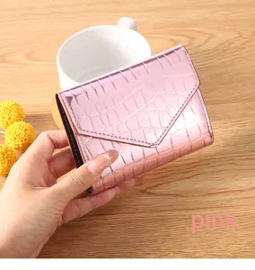 Close-up of pink laser crocodile pattern wallet detail, elegant flip wallet texture and design.