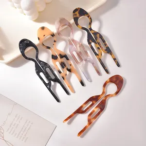 Macro dettaglio di eleganti forcine per capelli ambrate a tartaruga per acconciature chignon