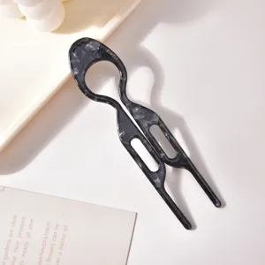 Primo piano di un'elegante forcina per capelli in acetato marmorizzato con design a U unico.