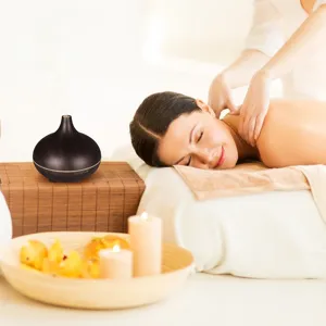 Essential oil diffuser shown in a relaxing spa and massage scene with a woman