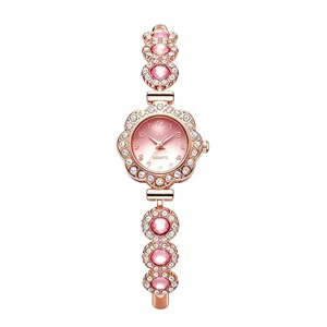 Primo piano di orologio da donna in oro rosa con strass rosa e quadrante a fiori