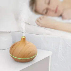 400ml wood grain aroma diffuser emitting mist in a cozy bedroom setting for sleep.