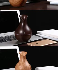Vue détaillée des humidificateurs de vase en bois clair et foncé sur un bureau près d'un PC