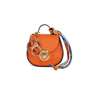 Mini llavero de bolso tipo silla de montar naranja elegante con herrajes dorados.