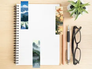 Detailed shot of landscape bookmarks featuring scenic mountain and nature views on a notebook.