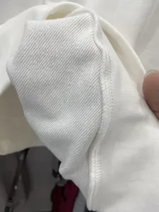Detailed close-up view of white heavy loopback cotton fabric showing interior fleece texture and seams.