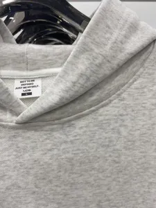 Primer plano detallado del cuello de la sudadera con capucha gris y su tejido suave.