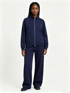 Detail view of a navy blue zip-up stand collar sweatshirt and wide-leg trousers outfit.