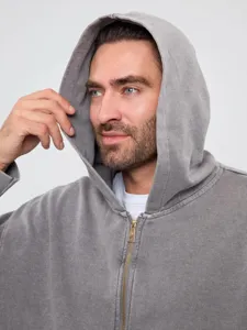Close-up of grey vintage washed zip-up hoodie, showing fabric texture and metal zipper detail.