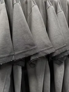 Close-up detail of mens vintage washed grey cotton t-shirt sleeve hem and shoulder texture.