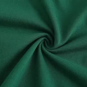 Detailed macro shot of dark green cotton knit fabric showing fine ribbed texture and soft feel.