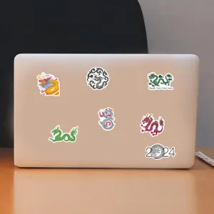 Detailed view of waterproof Year of the Dragon cartoon stickers neatly arranged on a laptop lid.