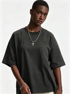 Detailed view of model wearing dark grey oversized drop shoulder tee and cross necklace.