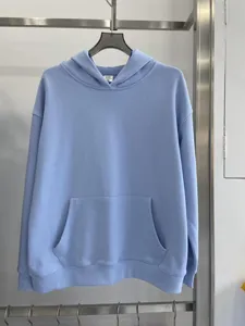 Vista detallada de sudadera con capucha azul claro de algodón pesado con bolsillo tipo canguro.