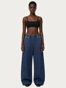 Detailed view of the stylish black crop top and washed blue denim wide-leg pants outfit.