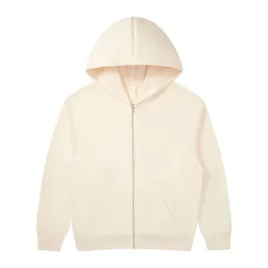 Zip hoodie detail view showing cream fabric texture, zipper, and pocket construction clearly.