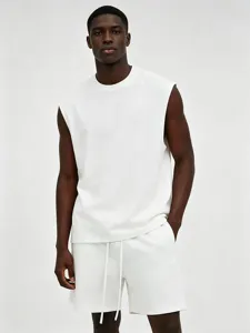 Men's solid white sleeveless tank top close-up detail, showing the premium fabric and clean cut.