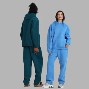 Detailed view of cozy fleece hoodie and sweatpants set in solid blue and green, casual winter style.