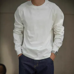 Detail shot of white heavy cotton raglan long sleeve shirt with model wearing casual denim.