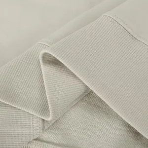 Close up view of light grey French terry fabric detail showing ribbed hem texture and soft material.