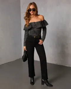 Detailed view of the stylish off-the-shoulder denim top with ruffled details and long sleeves.