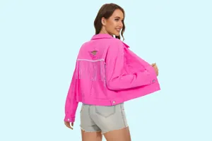 Gedetailleerd overzicht van het roze dames denim jasje met franjes en destroyed look.