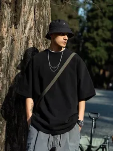 Detailed shot of heavy cotton dropped shoulder black t-shirt, casual streetwear style for men.