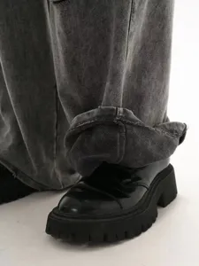 Detail view of men's distressed loopback sweatpants cuff paired with chunky platform shoes.