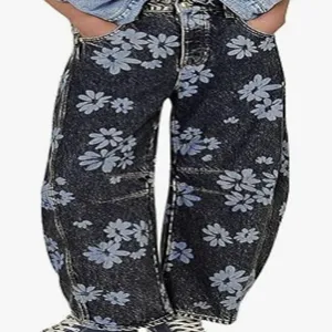 Detailed view of women's loose denim jeans featuring a stylish blue floral daisy print.