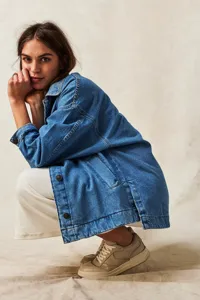 Detail shot of the casual oversized denim jacket featuring side slits, pockets, and chic styling.