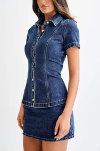 Detailed view of the dark blue denim short-sleeve button-up shirt and high-waisted skirt set.
