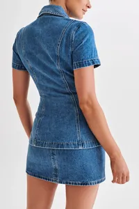 Detailed view of the stylish denim short-sleeve top and high-waist mini skirt set.