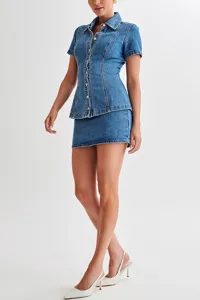 Detail view of the denim short-sleeve button-up shirt and matching mini skirt set in blue.