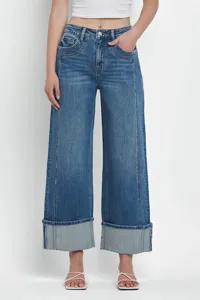 Detailed view of women's washed blue wide leg cuffed jeans with classic mid waist design.