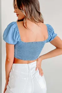 Light blue puff sleeve denim crop top back view featuring smocked back and chic square neck design.