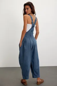 Vue détaillée du pantalon à bretelles en denim ample avec boucles de dos et poches latérales.