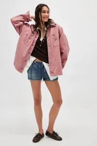 Detailed view showcasing the casual pink denim jacket, layered tops, and stylish shorts.